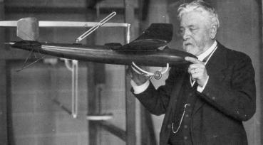 Gustave Eiffel dans son laboratoire tient une maquette de l'avion conçu par Victor Tatin